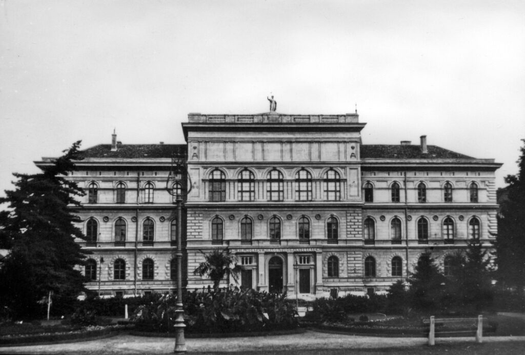 Az egyetem 1940–1944 között viselte Horthy Miklós kormányzó nevét. Ez azon kevés fotók egyike, amelyen látszik az ekkori kiírás, illetve itt még megvan az épületet díszítő szoboralak a tetőn, ami 1950-re már eltűnt