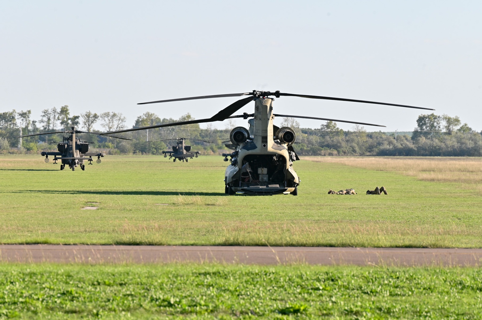 Előtérben a CH-47 Chinook szállító-, háttérben három AH-64D Apache harci helikopter a szegedi repülőtéren, 2024. október 7-én